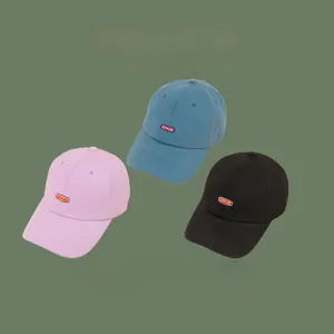 Flat lay of pink, blue and black cotton baseball caps with GOOD embroidered patch logo