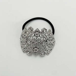 Detail of silver alloy hair tie featuring hollow floral carving with pearls and crystals
