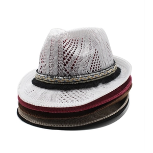 Close-up of hollow crochet knit jazz hats with colorful sequin and tassel band detailing