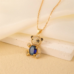 Close-up of teddy bear pendant with blue oval stone and micro-pave crystals on gold chain