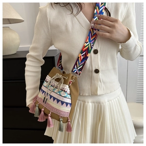 Close-up of ethnic bucket bag featuring colorful geometric embroidery and handmade tassels