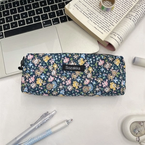 Detail of floral canvas pencil case with zipper and Sozakka label on stationery background