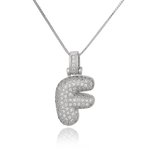 Macro detail of silver F-letter pendant with pavé cubic zirconia on a box chain