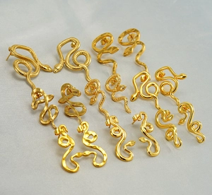 Macro view of various 18K gold plated snake-shaped stud earrings in different styles