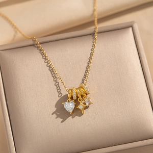Elegant 18k gold plated necklace with heart and star zircon charms on a jewelry box