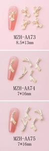Detailed view of gold bow nail charms with pearls and colorful rhinestones for DIY