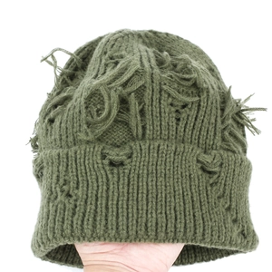 Detailed view of dark green distressed knit beanie featuring street style ripped textures