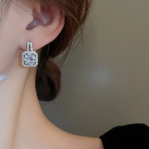 Macro shot of a luxury square geometric stud earring featuring a large sparkling zircon