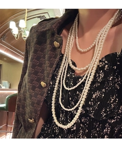 Detail of layered vintage glass pearl necklace showing elegant cream-white pearls