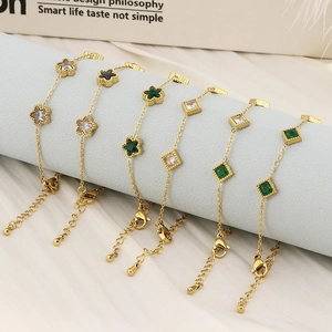 Detailed macro view of 18K gold plated bracelets featuring emerald and black zircon inlays