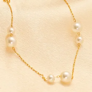 Elegant gold chain bracelet with polished white pearls on a soft silk background