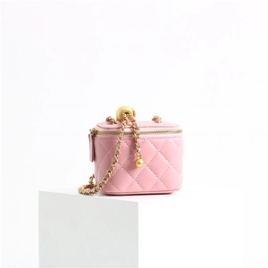 Macro detail of pink quilted leather texture and gold-tone chain with metal adjustment ball