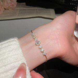Close-up of gold flower bracelet with marquise zircon leaves and adjustable slide clasp