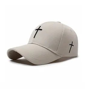 Detailed view of beige baseball cap with black cross embroidery on cotton twill fabric