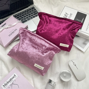 Macro shot of plush velvet makeup bags with brand label in a stylish lifestyle setting