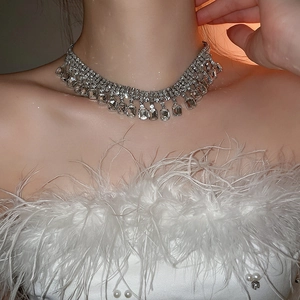 Detailed view of luxury layered silver fringe necklace with rectangular crystals on model