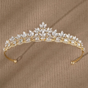 Elegant gold bridal tiara with marquise rhinestones and crystals on a beige background