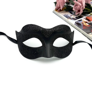 Detail of black lace masquerade mask with glitter patterns and elegant silk ribbon ties