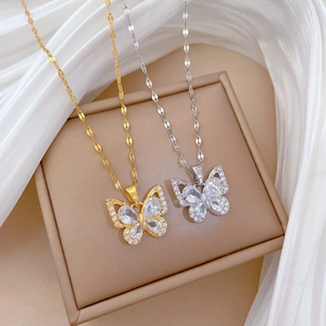 Macro detail of gold and silver butterfly necklaces with sparkling zircon inlay
