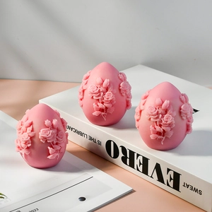Detailed view of three pink egg-shaped candles with intricate 3D floral rose carvings