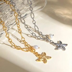 Detail of 18k gold and silver starfish pendants with white pearls on thick O-chains
