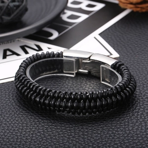 Close-up of black braided leather texture with silver magnetic stainless steel clasp