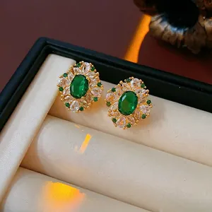Boucles d'oreilles émeraude vintage dorées avec zircons dans un écrin de luxe
