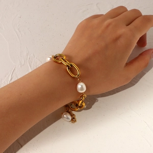 Macro detail of French vintage gold chain link bracelet with oversized freshwater pearls