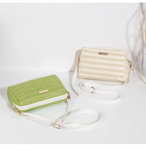 Detail of green and beige woven crossbody bags featuring gold zippers and fine textures