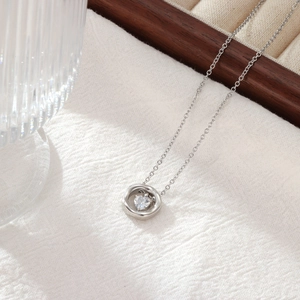 Élégant collier en acier titane avec pendentif cœur sur fond de tissu blanc