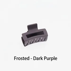 Detail view of small matte dark purple hair claw clip with focus on spring and teeth