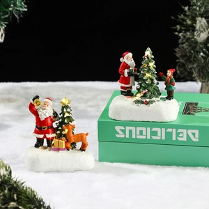 Lighted Christmas resin village figures with Santa Claus and reindeer on faux snow