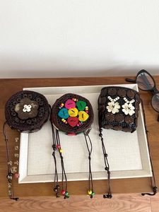 Detail of three handmade ethnic mini crossbody bags with coconut shells and wood beads