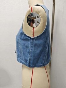 Detail view showing side seam and armhole cut of this cropped blue denim vest