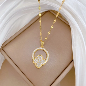 Detail of clover pendant with white rhinestones on a gold flat O-chain necklace