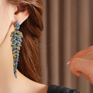 Gros plan de boucles d'oreilles feuille vintage avec strass colorés sur l'oreille