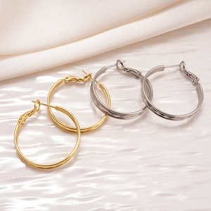 Boucles d'oreilles doubles anneaux en or 18 carats et argent sur plateau blanc
