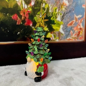 Close-up of lighted Christmas gnome tree with colorful LEDs and green gift box decoration