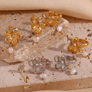 Détail de boucles d'oreilles fleur 18K avec zircon rectangulaire et pendentif perle