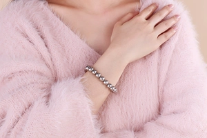 Close-up of minimalist silver beaded bracelet worn on wrist with elegant metal luster