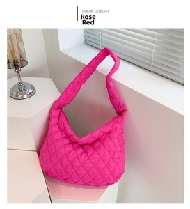 Dettaglio della borsa a tracolla trapuntata rosa rosso con morbida trama in nylon