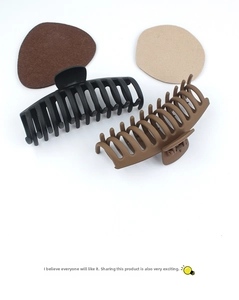 Detail of matte black and coffee hair claw clips with multi-tooth interlocking grip