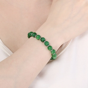 Green beaded bracelet with silver spacers on wrist, elastic unisex jewelry design