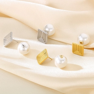 French vintage square gold and silver earrings with pearls on beige silk fabric
