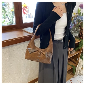 Brown leather underarm bag featuring a stylish plaid bow detail and buttons