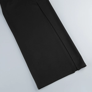 Detail view of the black knit skirt featuring a high side slit and refined stitching