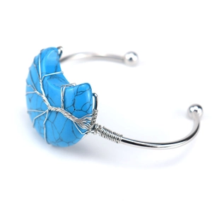 Detailed silver wire-wrapped tree of life design with turquoise crescent moon on a cuff