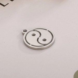 Macro shot of silver Tai Chi Yin Yang pendant with intricate hollow metal design