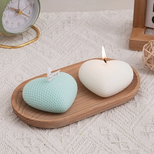 Handwoven heart scented candles in mint and cream on a rustic wooden tray for home decor