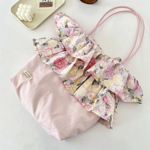 Detail van roze schoudertas met vintage bloemen ruches en elegante stoffen textuur